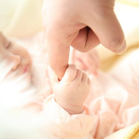 Heartwarming close-up of a baby holding a parent's finger, symbolizing love and connection.